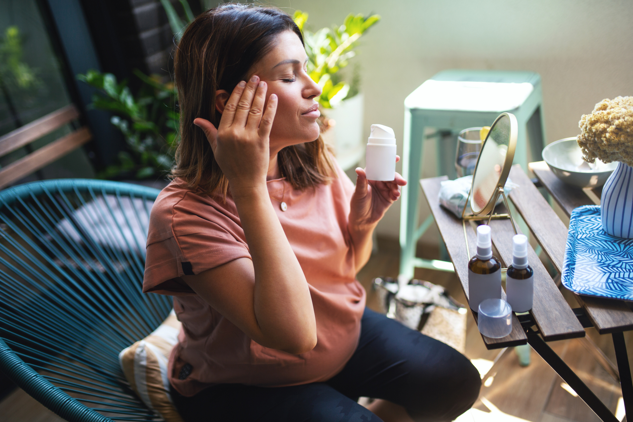 Pregnant Woman Moisturizes Her Face.