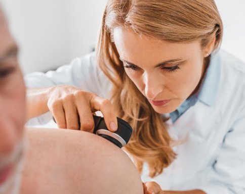 woman dermatology provider doing a full body screening to an elder person